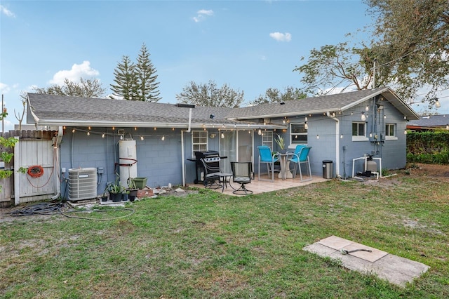 back of property with cooling unit, a lawn, and a patio