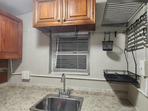 kitchen featuring light stone countertops and sink