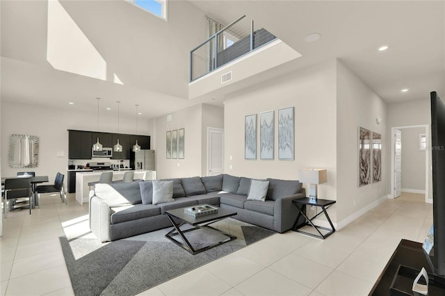 living room with a high ceiling and light tile patterned flooring