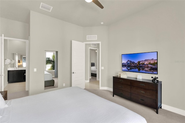 carpeted bedroom with ensuite bathroom and ceiling fan