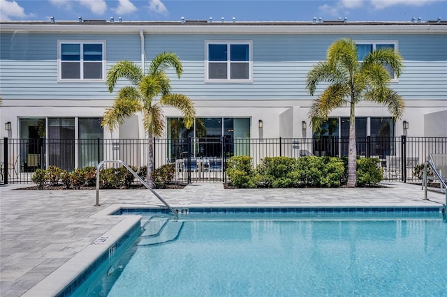 rear view of property featuring a community pool and a patio area