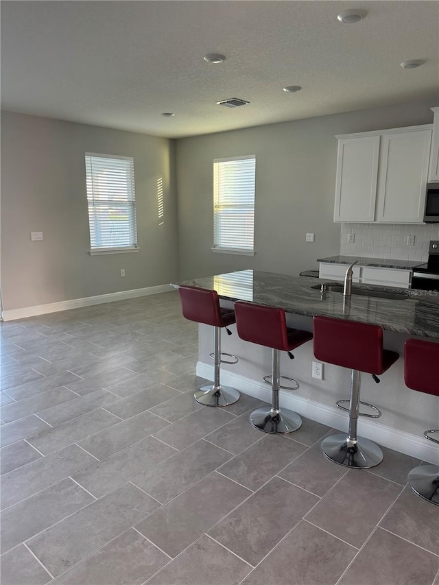 kitchen featuring a breakfast bar, a wealth of natural light, and appliances with stainless steel finishes