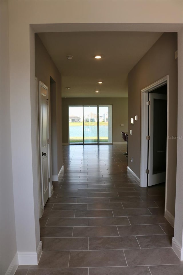 hall featuring recessed lighting and baseboards