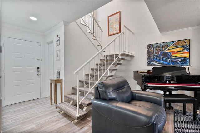 foyer entrance with hardwood / wood-style flooring and crown molding