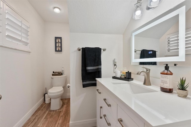 bathroom featuring vanity, toilet, hardwood / wood-style floors, and a textured ceiling