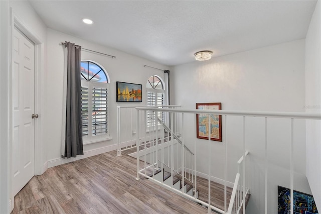 stairs featuring hardwood / wood-style floors and a textured ceiling