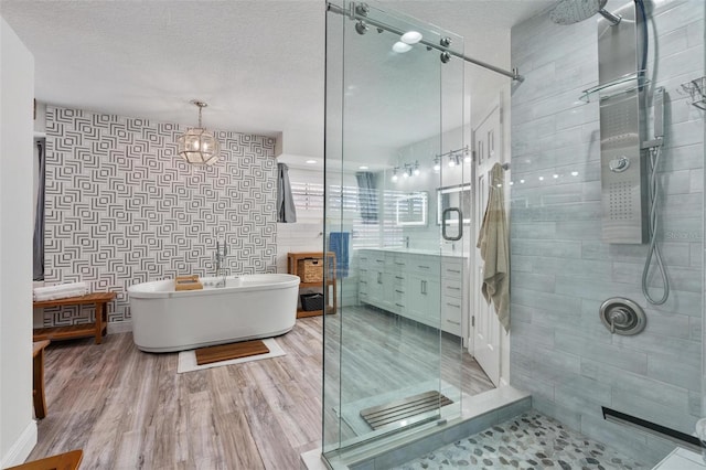 bathroom with vanity, hardwood / wood-style floors, a textured ceiling, and separate shower and tub