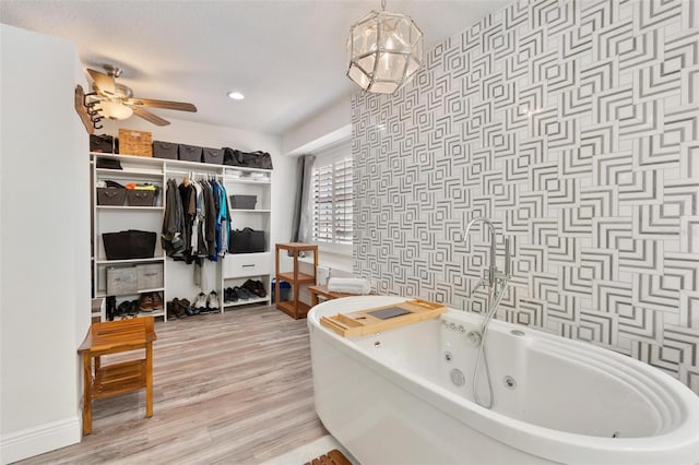 bathroom featuring ceiling fan, a bathing tub, and hardwood / wood-style floors