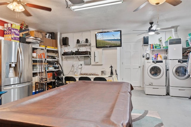 kitchen featuring white cabinetry, stainless steel fridge, washer and dryer, and a textured ceiling