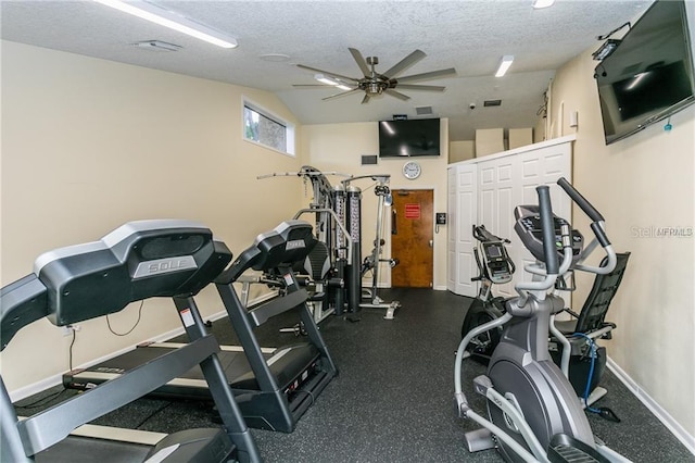 workout area featuring ceiling fan, vaulted ceiling, and a textured ceiling