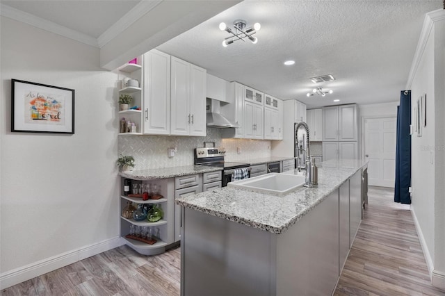 kitchen with white cabinetry, light stone counters, an island with sink, electric stove, and wall chimney range hood