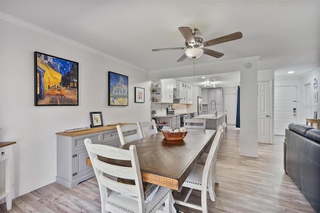 dining room featuring ornamental molding, sink, ceiling fan, and light hardwood / wood-style floors