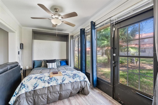 bedroom with crown molding, ceiling fan, and light hardwood / wood-style floors