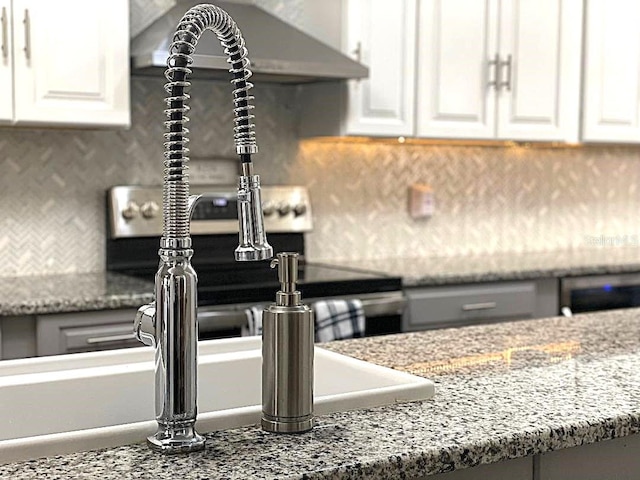 kitchen featuring white cabinetry, backsplash, and light stone counters