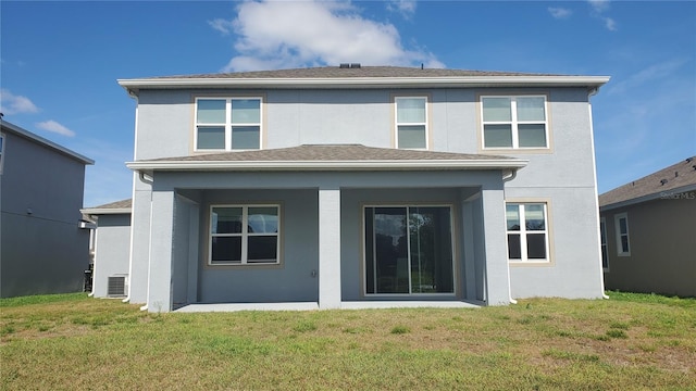 rear view of property with central air condition unit and a lawn