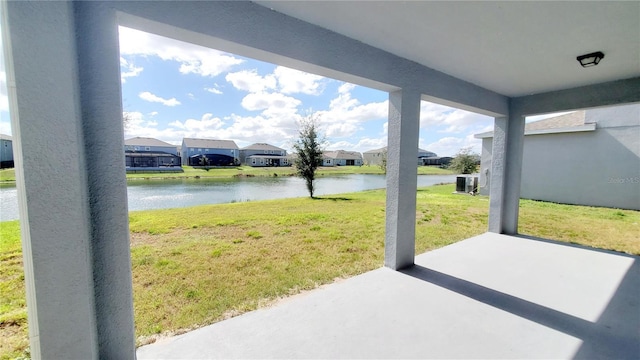 exterior space featuring cooling unit, a patio, and a water view