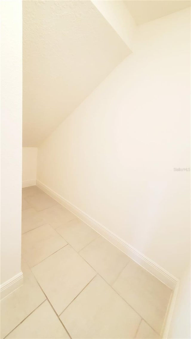 interior space with tile patterned flooring and vaulted ceiling