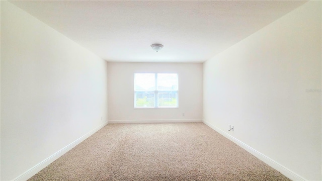 spare room featuring light colored carpet