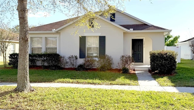 bungalow with a front lawn and stucco siding