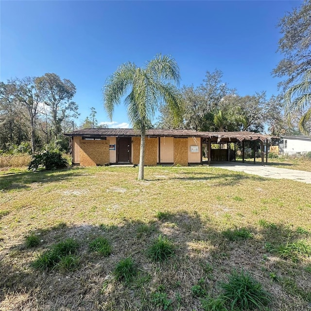 view of front facade featuring a front yard and a carport