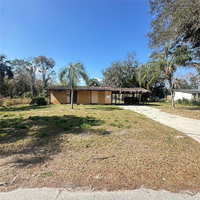 ranch-style home featuring a carport and a front yard