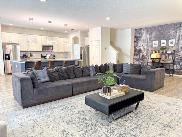 living room with a textured ceiling and light hardwood / wood-style flooring