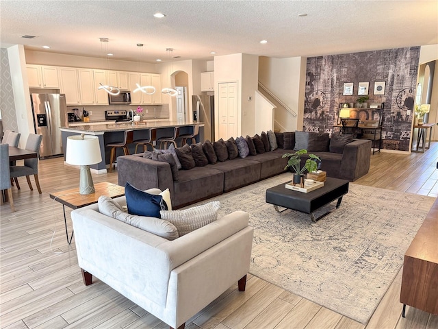 living room with a textured ceiling and light wood-type flooring