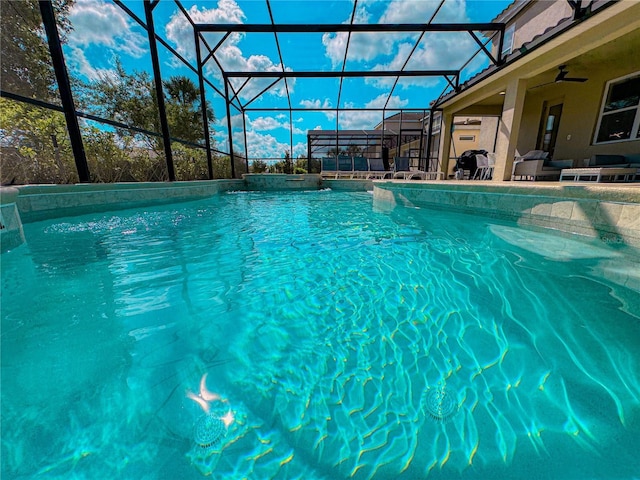 view of pool featuring pool water feature, ceiling fan, and glass enclosure