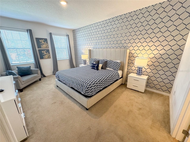 bedroom with light colored carpet and a textured ceiling