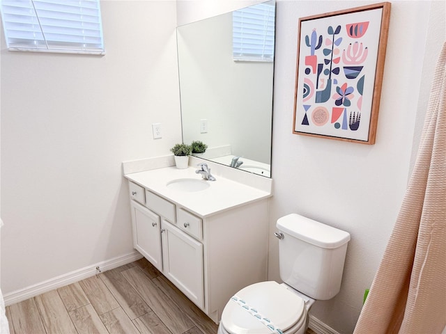 bathroom with vanity, wood-type flooring, and toilet