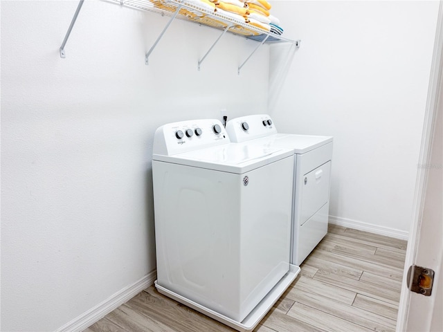 laundry area featuring light hardwood / wood-style flooring and washing machine and dryer