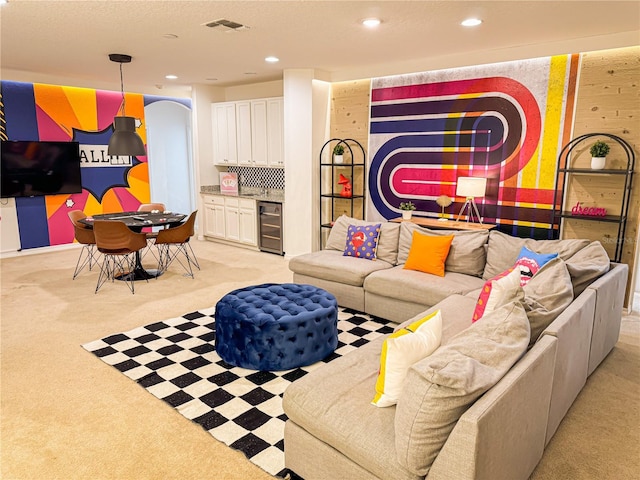 living room featuring bar, light colored carpet, and beverage cooler