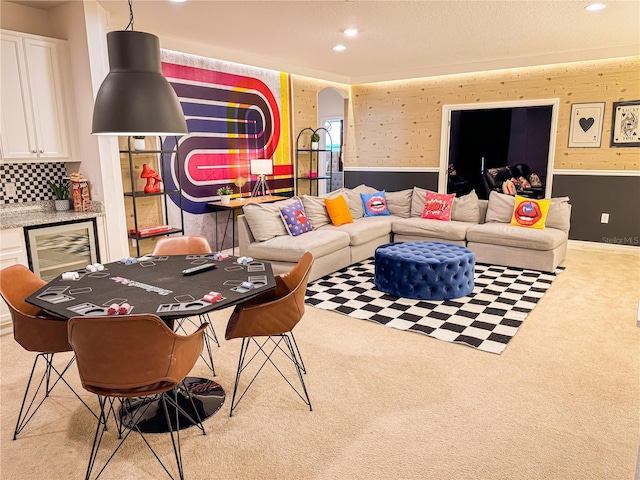 living room with light carpet, beverage cooler, and indoor bar