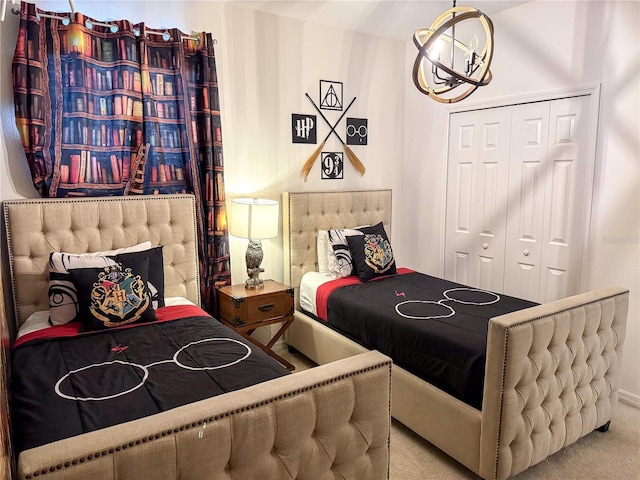 bedroom with an inviting chandelier, a closet, and carpet flooring