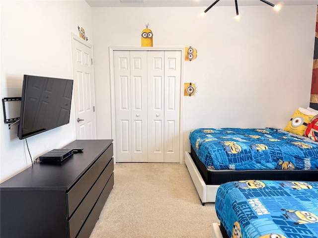 bedroom with light carpet and a closet