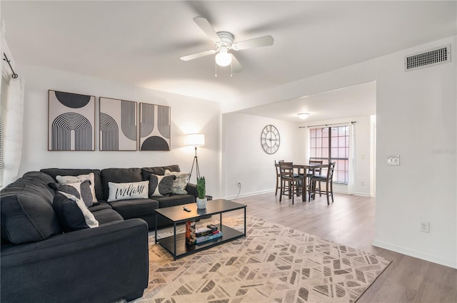 living room featuring hardwood / wood-style floors and ceiling fan