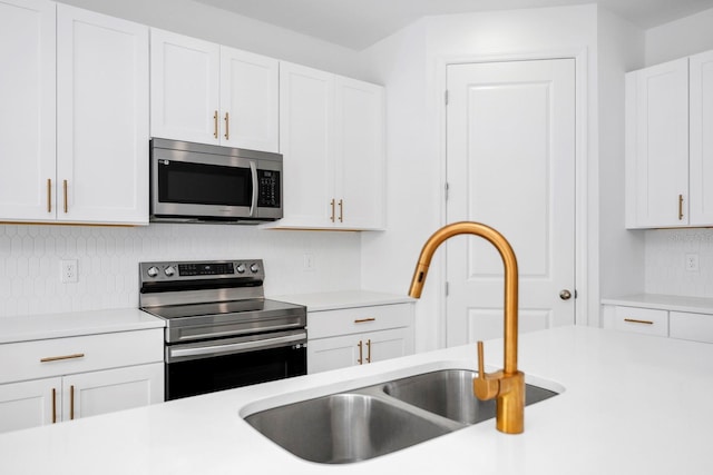 kitchen featuring stainless steel appliances, sink, and white cabinets