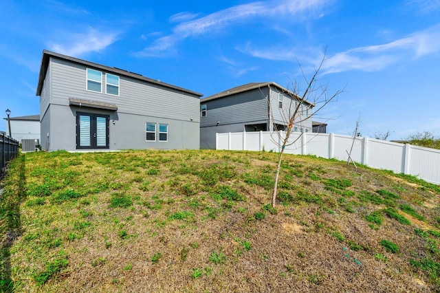 rear view of house with french doors, a lawn, and central air condition unit