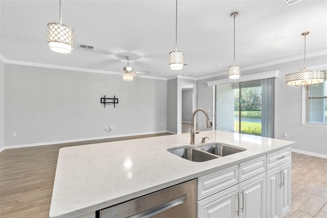 kitchen featuring sink, white cabinets, stainless steel dishwasher, light stone countertops, and a center island with sink