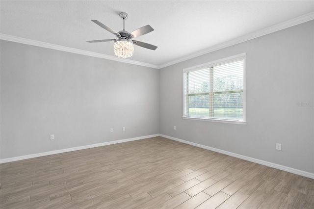 spare room featuring ornamental molding, ceiling fan, light wood-style flooring, and baseboards