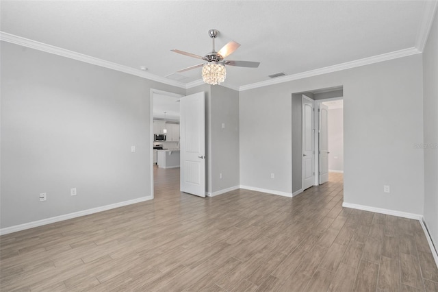 empty room featuring crown molding, ceiling fan, and light wood-type flooring