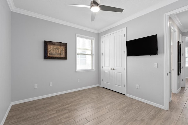 unfurnished bedroom featuring light wood finished floors, baseboards, a ceiling fan, ornamental molding, and a closet