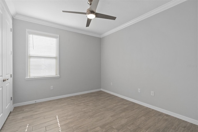 spare room with baseboards, light wood finished floors, a ceiling fan, and crown molding