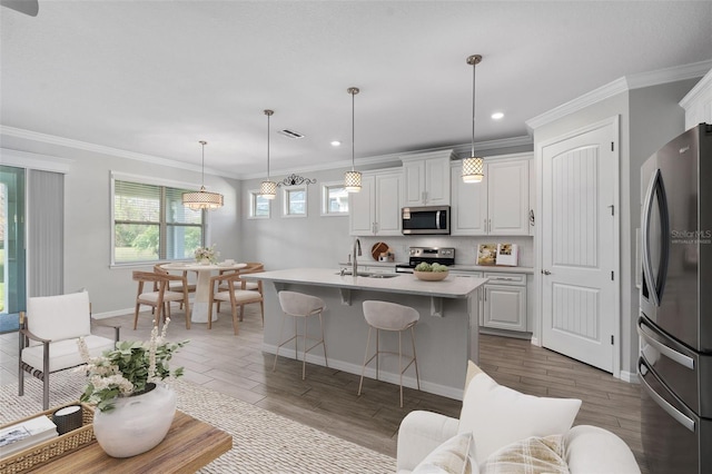 kitchen with visible vents, stainless steel appliances, light countertops, white cabinetry, and a sink