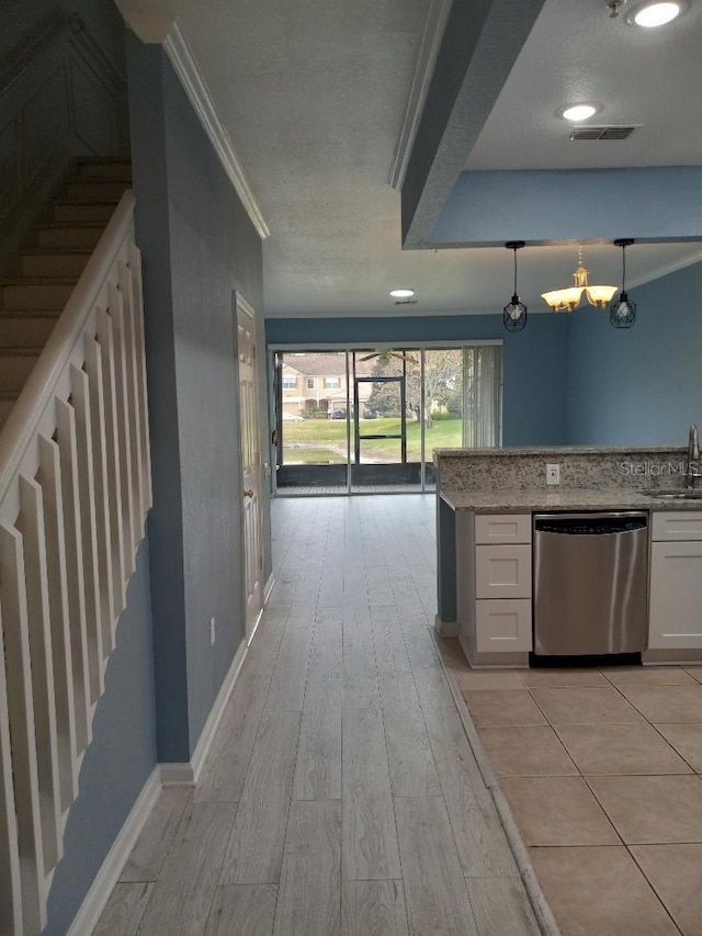 kitchen featuring decorative light fixtures, white cabinetry, dishwasher, sink, and ornamental molding