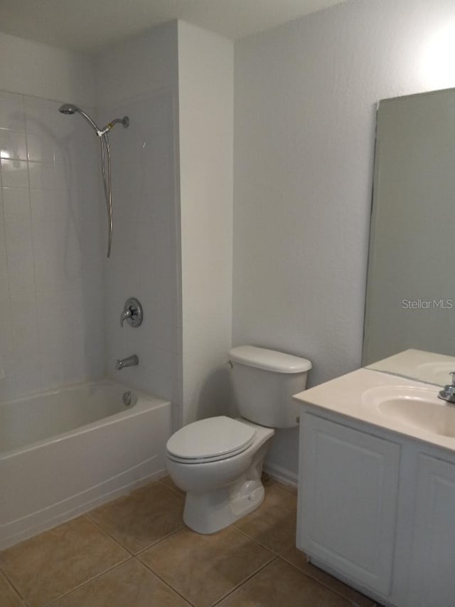 full bathroom featuring tile patterned flooring, tiled shower / bath, vanity, and toilet