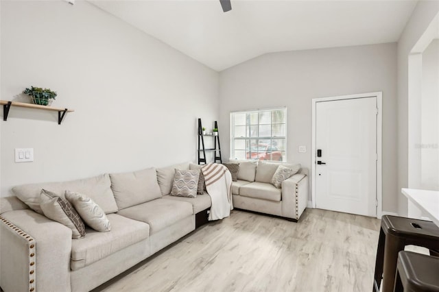 living room featuring ceiling fan, light hardwood / wood-style floors, and vaulted ceiling