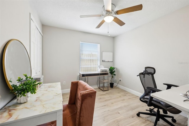 office area featuring ceiling fan, light hardwood / wood-style floors, and a textured ceiling