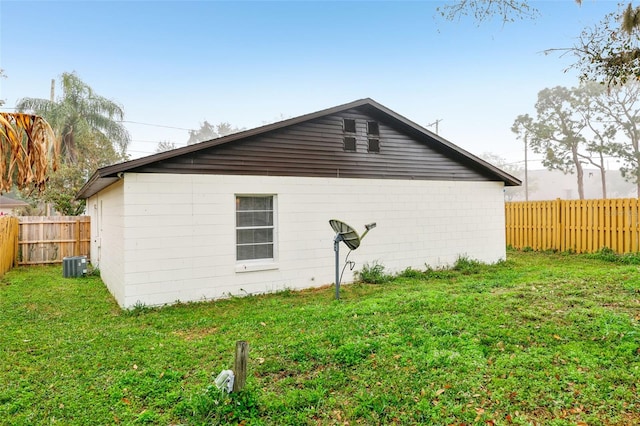 view of side of property featuring central AC and a lawn