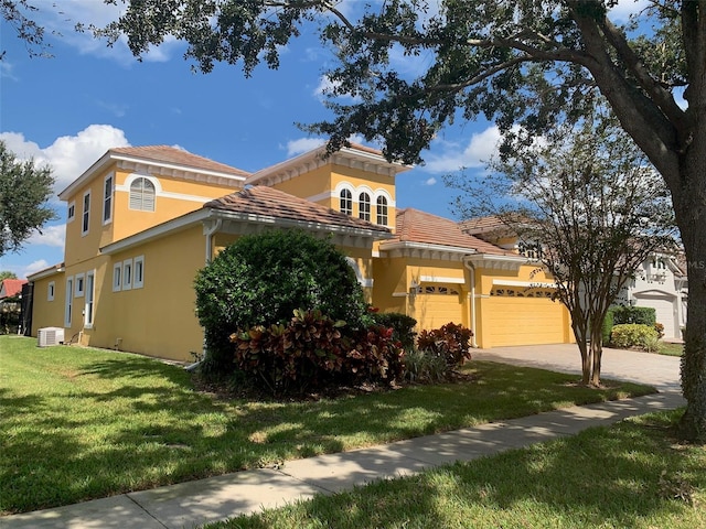 view of front facade with a front yard, stucco siding, concrete driveway, a garage, and a tiled roof